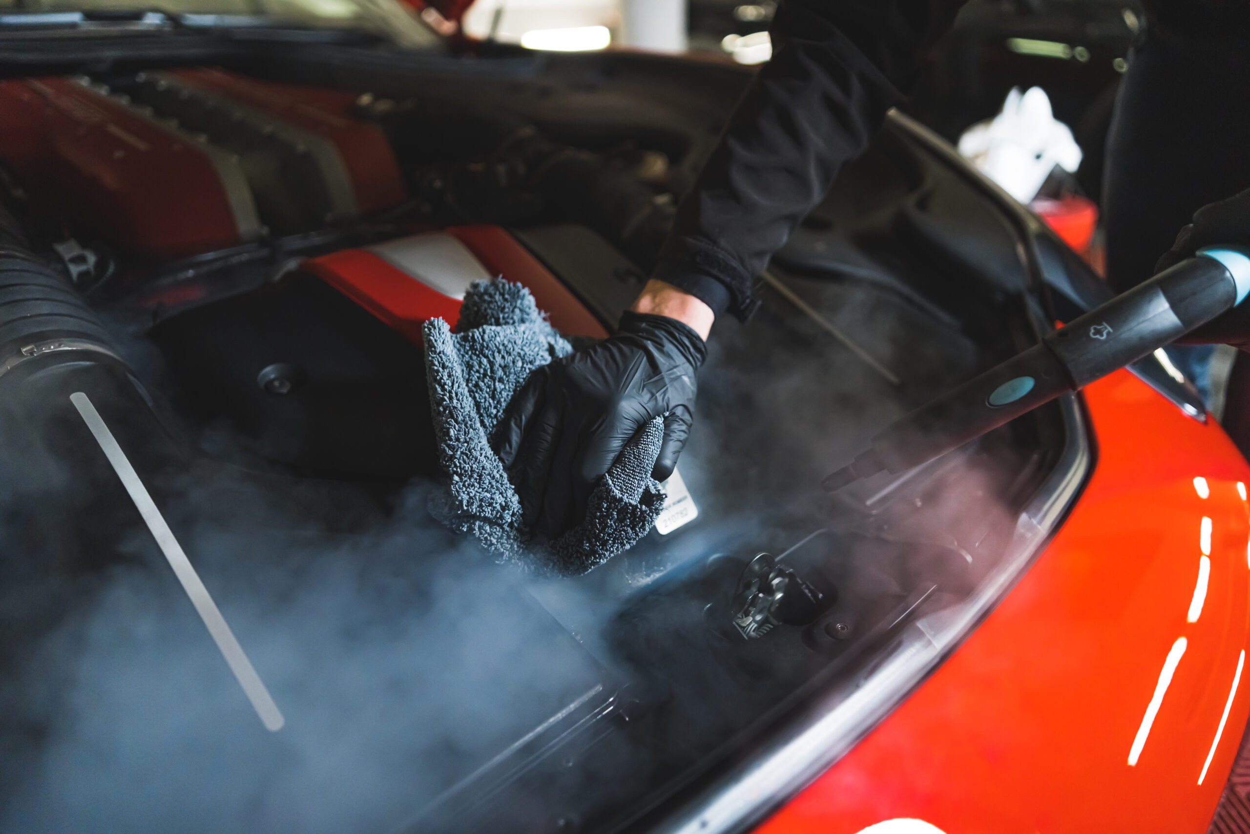 closeup shot of a person cleaning a car engine, car detailing concept. High quality photo