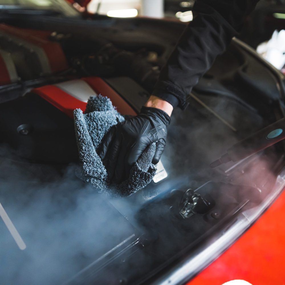 closeup shot of a person cleaning a car engine, car detailing concept. High quality photo